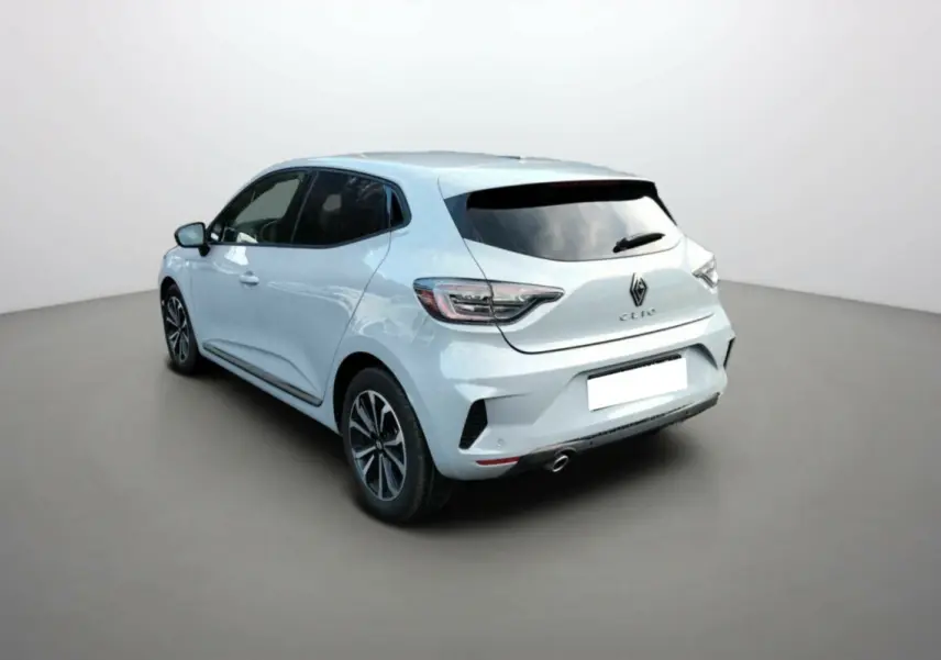 Vue 3/4 arrière droite d'une Renault Clio gris clair avec vitres surteintées et jantes alliage noires.