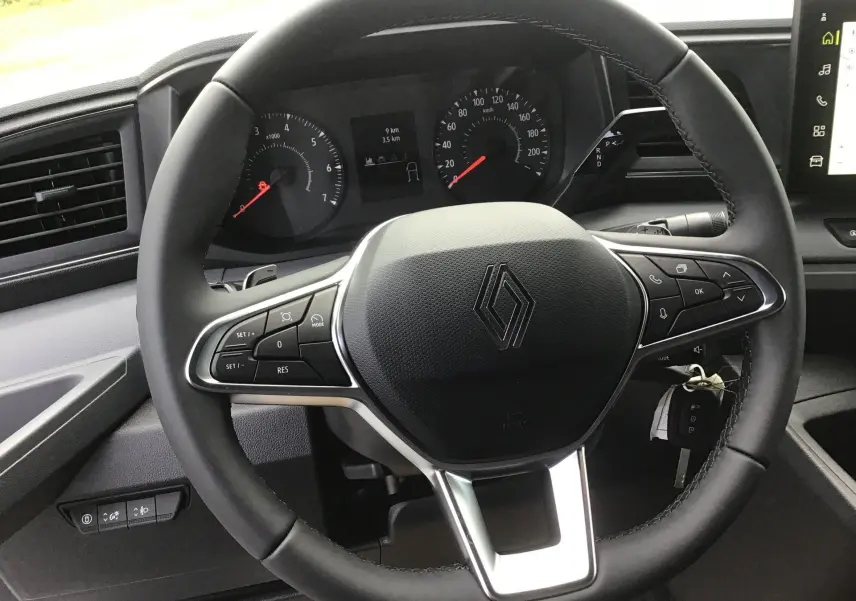 Vue rapprochée du volant noir du Renault Master 2025 avec commandes intégrées et tableau de bord digital.