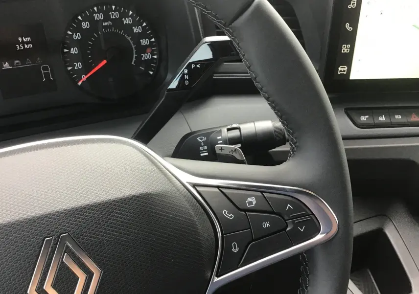Vue rapprochée du volant noir du Renault Master 2025 avec commandes intégrées et tableau de bord digital.