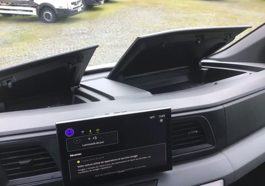 Vue intérieure du tableau de bord du Renault Master blanc 2025, avec double rangement ouvert et écran tactile central allumé.