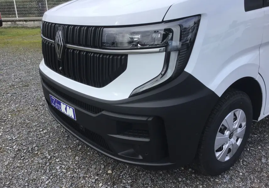 Gros plan sur l’avant droit du Renault Master blanc 2025 avec calandre noire et phares modernes.