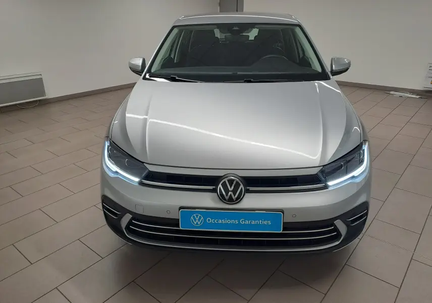 Vue avant d'une Volkswagen Polo 2025 couleur reflet d'argent avec feux LED allumés dans un showroom.