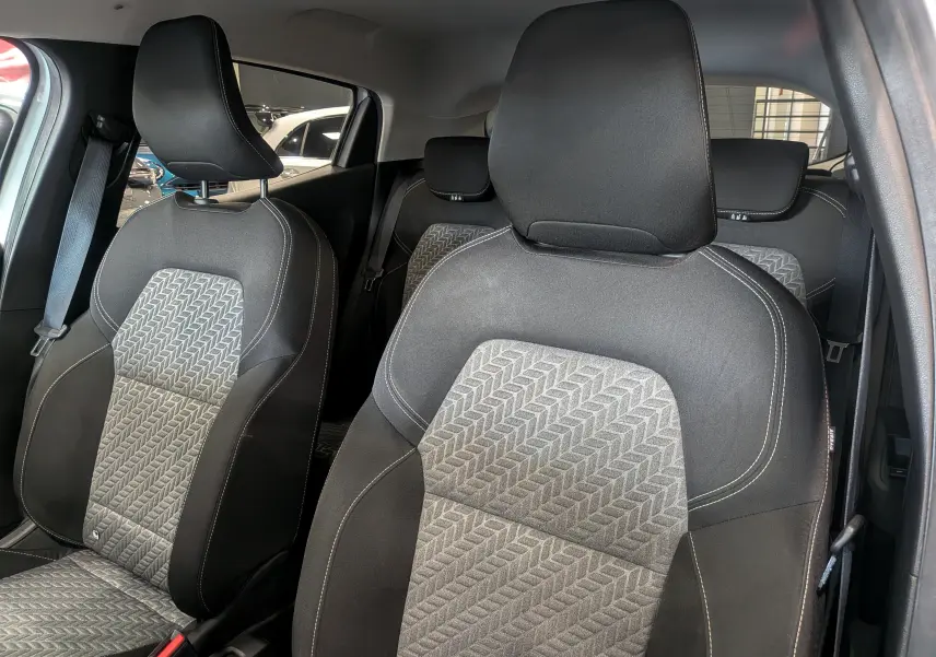 Vue intérieure sur les sièges avant en tissu gris à motifs géométriques de la Renault Clio V TCe 100 CH GPL Evolution 2023.