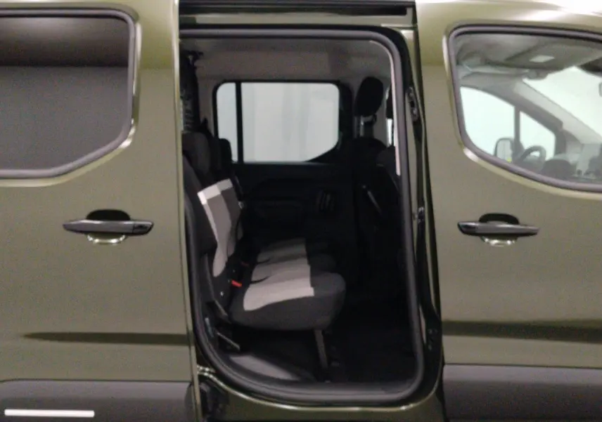Vue latérale gauche du Citroën Berlingo Multispace 2026 Sirkka Green avec porte coulissante ouverte et sièges arrière visibles.