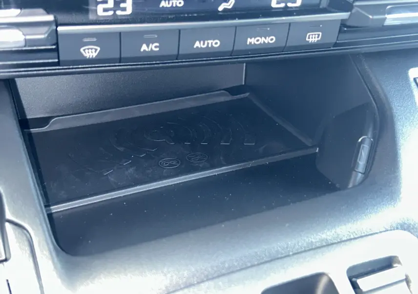 Gros plan sur la console centrale du Citroën Berlingo Multispace 2026, zone de recharge sans fil et commandes de climatisation.