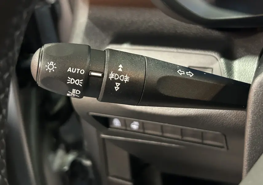 Gros plan sur la commande des phares et clignotants du Citroën Berlingo Multispace III Ph.2, intérieur noir.