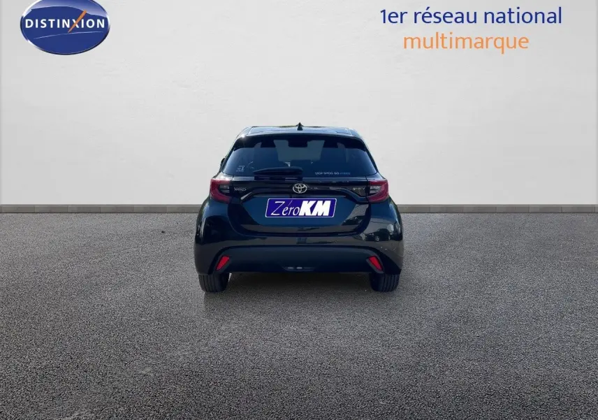 Vue arrière d'une Toyota Yaris Hybrid 116ch noire métal, avec feux arrière LED et logo distinctif sur hayon.