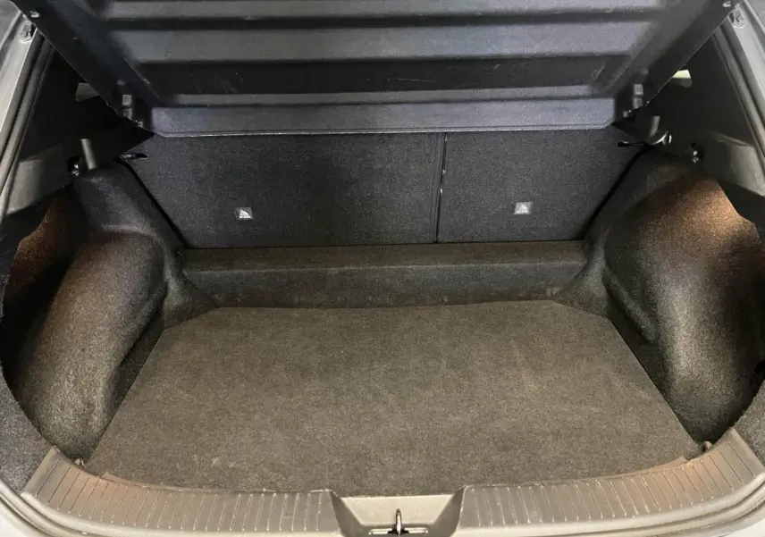 Coffre ouvert du Nissan Qashqai 1.3 Mild Hybrid 2023, vue intérieure spacieuse avec revêtement noir.