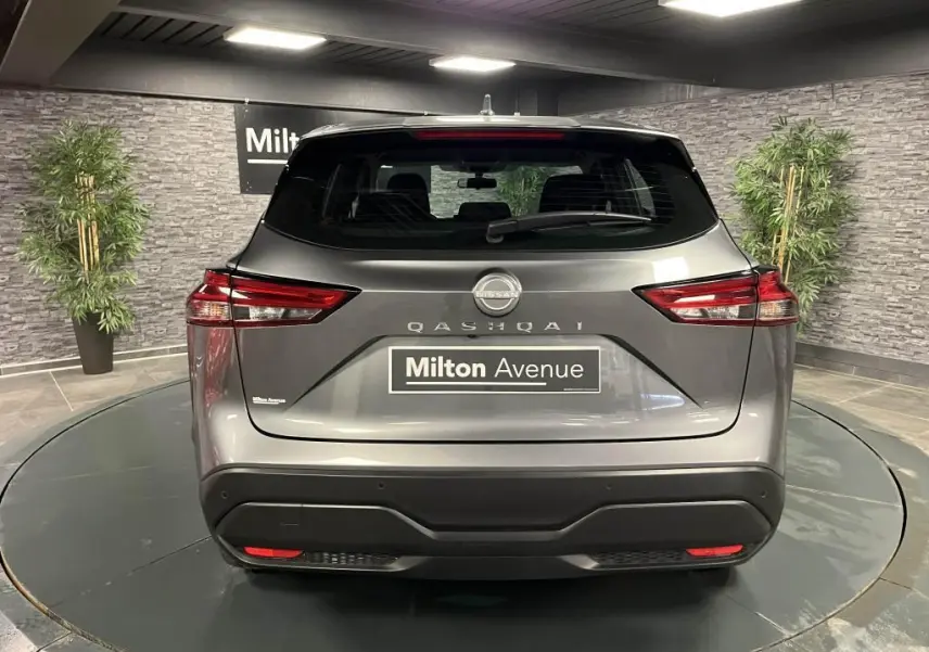 Vue arrière d'un Nissan Qashqai gris métallisé 2023 avec feux arrière LED et logo central visible.