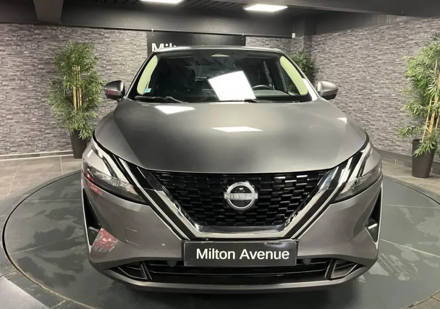 Vue frontale d'un Nissan Qashqai gris métallisé avec calandre noire et logo Nissan bien visible
