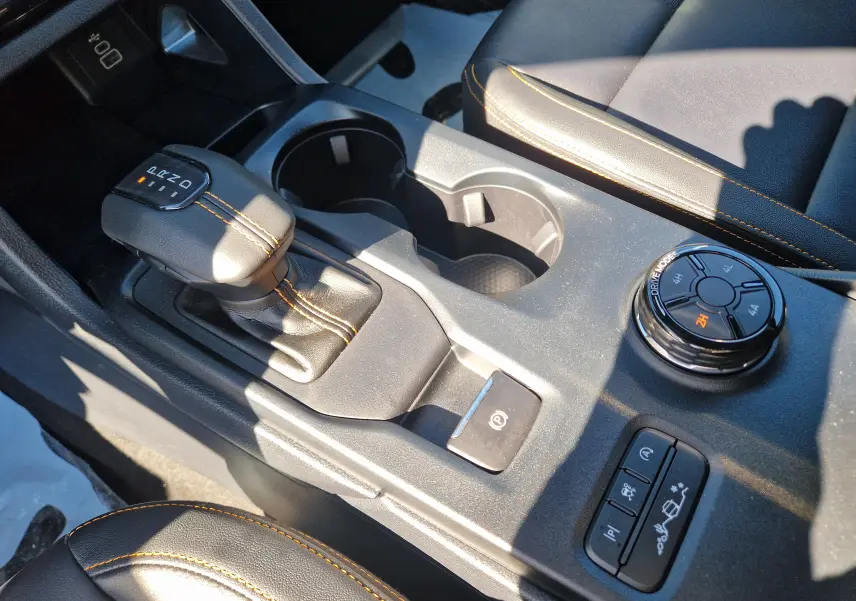 Gros plan sur la console centrale du Ford Ranger Wildtrak gris carbone, avec levier de vitesse et commandes de modes de conduite.