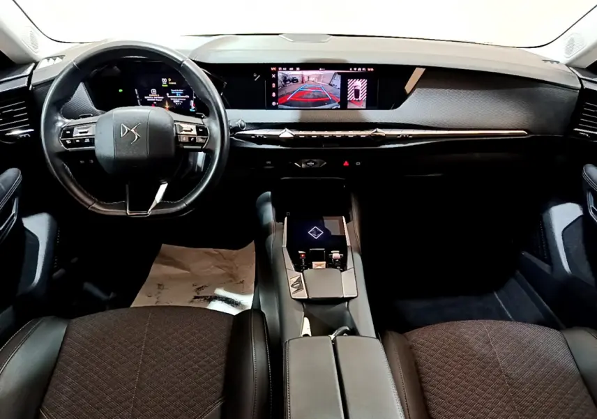 Intérieur noir du DS4 E-TENSE 2023 vu de face, avec volant cuir et écran tactile central affichant la caméra de recul