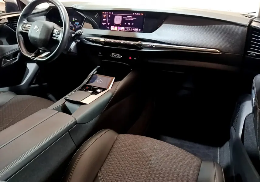 Intérieur noir de la DS4 E-TENSE 2023 vu côté passager, avec tableau de bord digital et volant cuir multifonctions.
