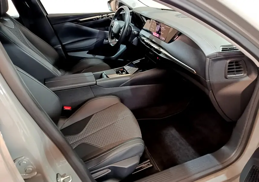 Intérieur côté conducteur du DS4 E-TENSE 2023, sièges noirs, tableau de bord numérique et volant cuir multifonctions.