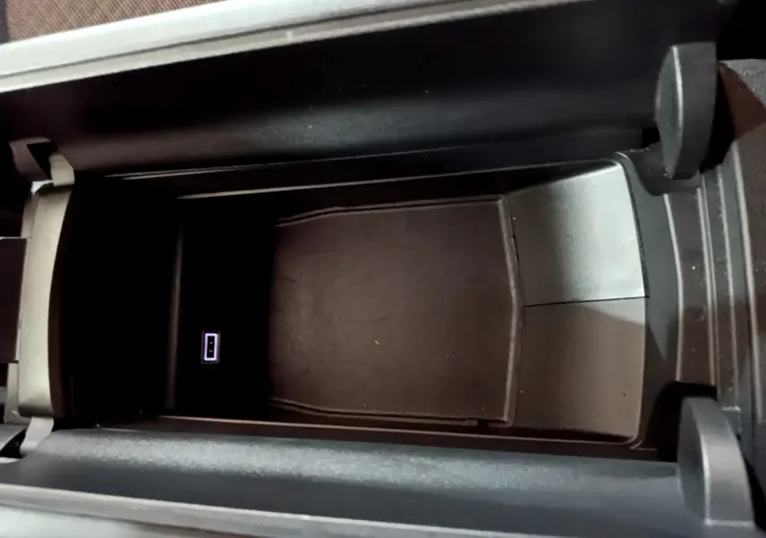 Vue rapprochée de la console centrale ouverte du DS4 E-TENSE 225 TROCADERO avec port USB visible, intérieur noir.