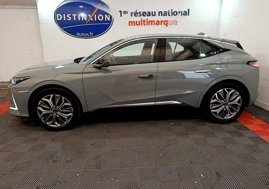 Profil côté gauche d'une DS4 E-TENSE 225 TROCADERO gris foncé 2023 avec jantes alliage et toit noir contrasté.