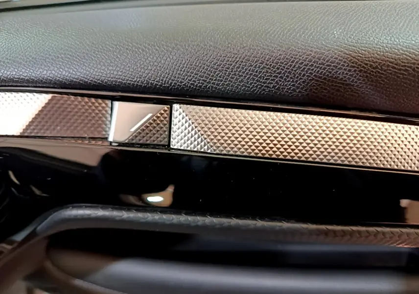 Détail du tableau de bord noir et argenté du DS4 E-TENSE 225 TROCADERO 2023, finition texturée élégante.