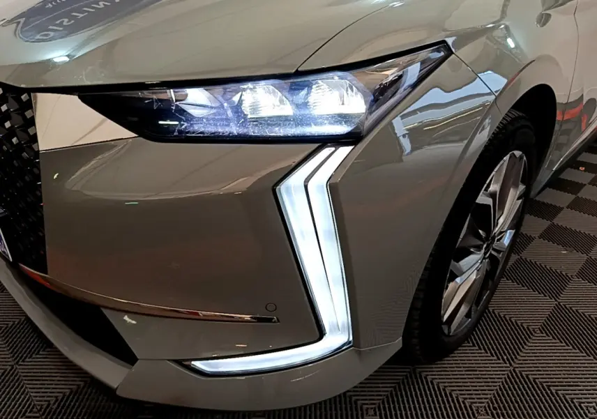 Gros plan sur l'avant droit gris foncé du DS4 E-TENSE 225 avec ses phares LED et feux diurnes en forme de flèche.