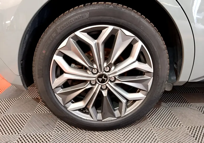 Gros plan sur la roue avant droite gris foncé du DS4 E-TENSE 225 TROCADERO avec jante alliage au design géométrique.