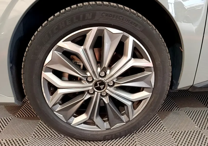 Gros plan sur la roue avant droite gris foncé du DS4 E-TENSE 225 TROCADERO avec jante alliage au design géométrique.