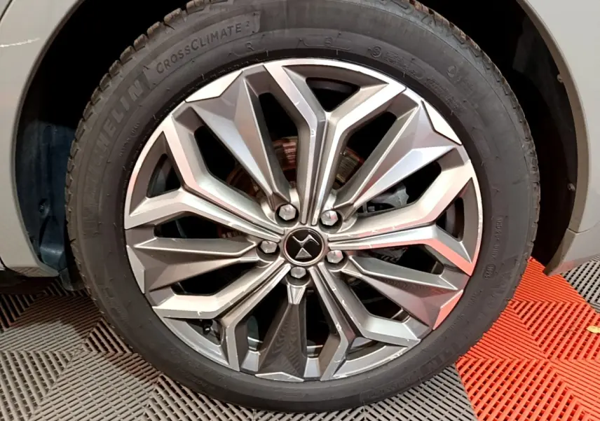 Gros plan sur la jante alliage au design géométrique du côté avant droit d'un DS4 E-TENSE gris foncé 2023