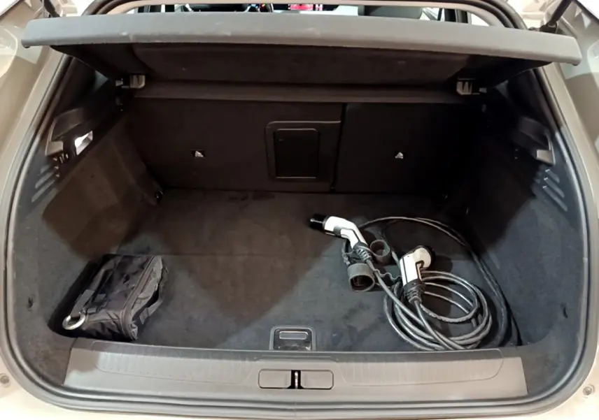 Coffre ouvert d'une DS4 E-TENSE 225 gris foncé, avec câble de recharge hybride visible à l'intérieur.