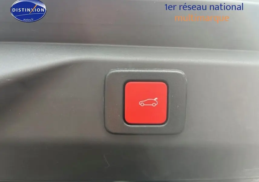 Bouton rouge d'ouverture électrique du coffre sur un Peugeot 3008 gris Artense, vue rapprochée intérieure.