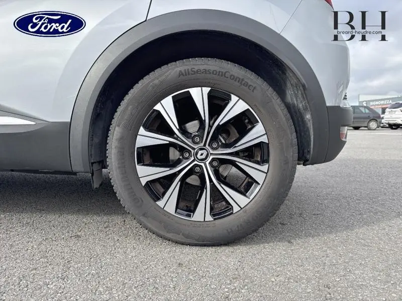 Gros plan sur la roue arrière droite du Renault Captur gris Highland 2023 avec jante alu bicolore distinctive.