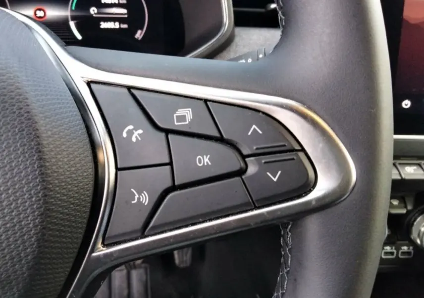Gros plan sur les commandes multifonctions à droite du volant cuir noir de la Renault Clio Gris Rafale 2025.