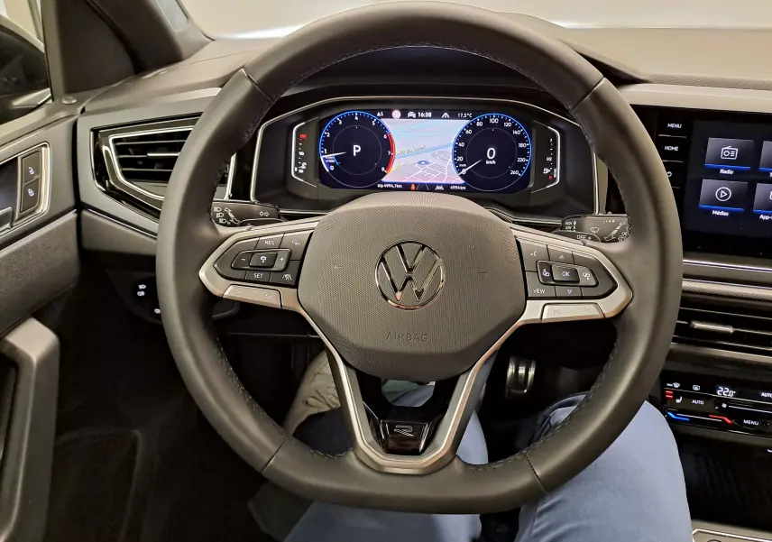 Vue intérieure centrée sur le volant cuir noir du Volkswagen Taigo 2025 avec tableau de bord digital et écran tactile.