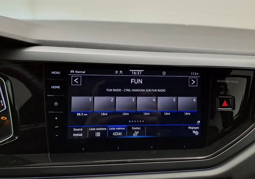 Écran tactile central du Volkswagen Taigo 2025 affichant la radio FUN, entouré de commandes noires brillantes.