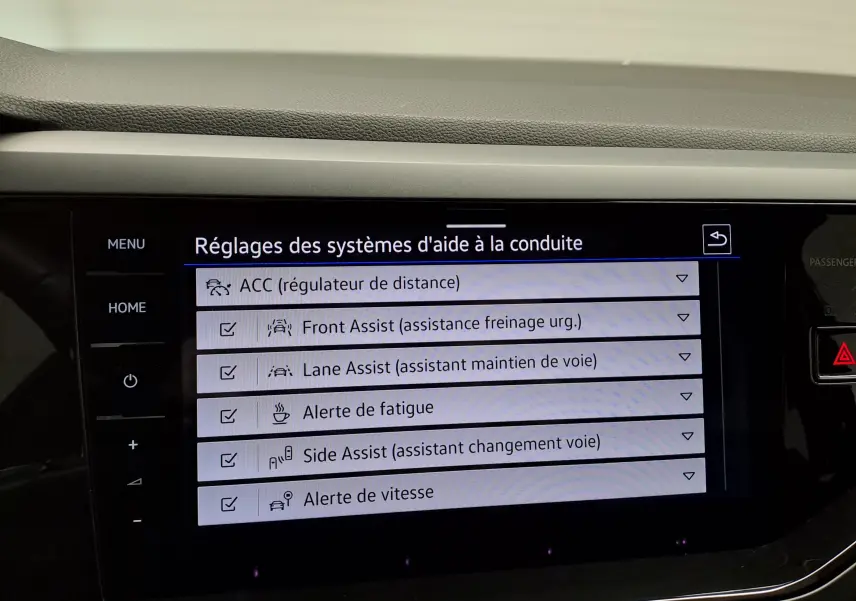 Écran tactile intérieur affichant les réglages des aides à la conduite du Volkswagen Taigo noir intense nacré.