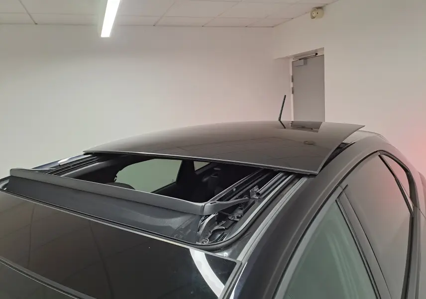 Vue rapprochée du toit ouvrant électrique ouvert sur un Volkswagen Taigo noir intense nacré, côté droit.