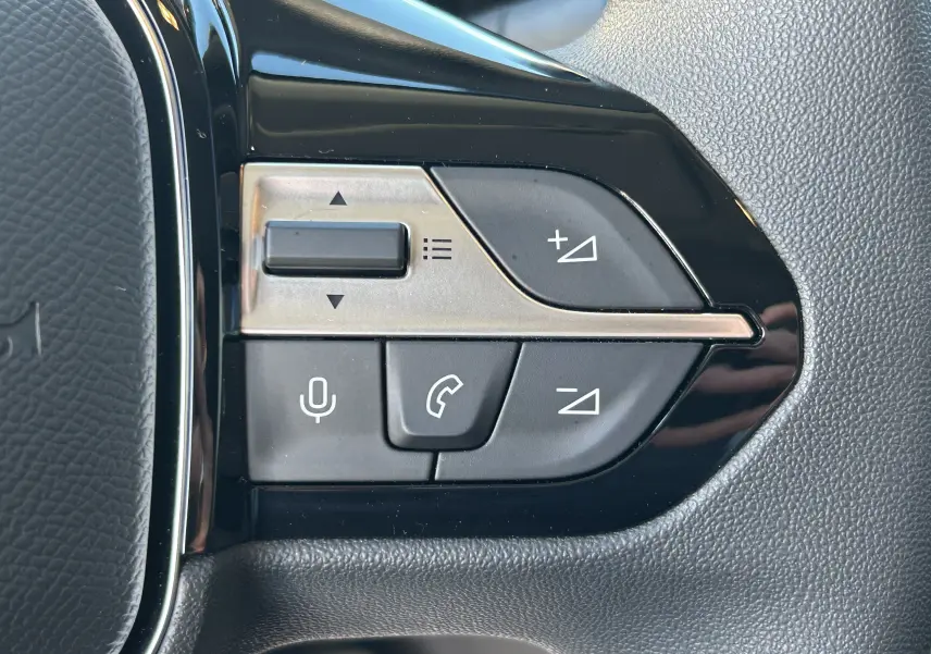 Gros plan sur les commandes de volume et téléphone sur le volant noir du Peugeot Partner Fourgon gris acier.