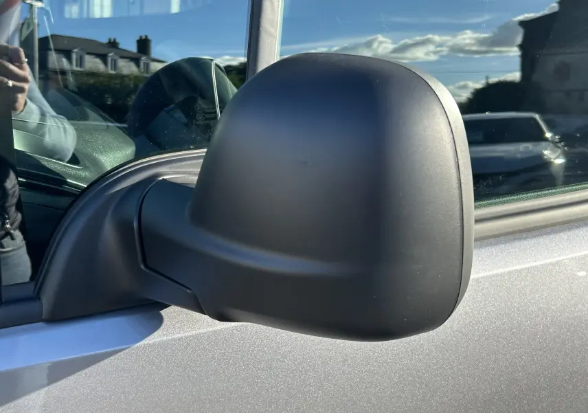 Rétroviseur latéral droit noir mat sur Peugeot Partner Fourgon gris acier, vue rapprochée en extérieur.