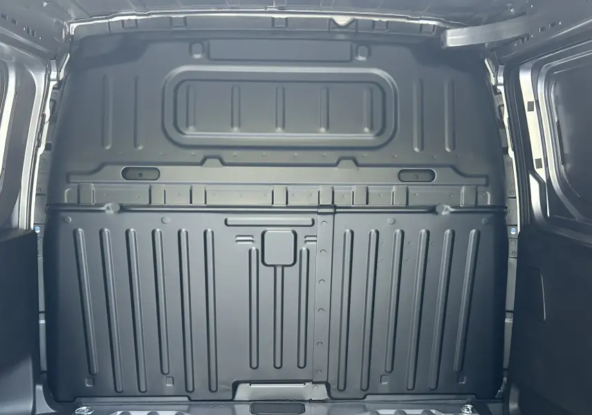 Vue intérieure arrière du fourgon Peugeot Partner III Ph.2 gris acier, montrant la cloison métallique de séparation du coffre.