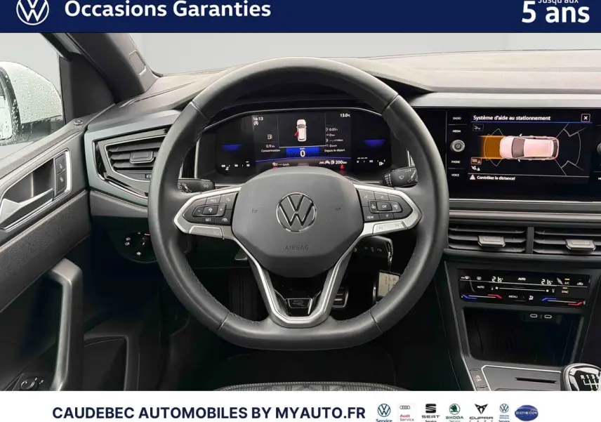 Vue intérieure centrée sur le volant cuir multifonctions et le tableau de bord digital d'une Volkswagen Polo blanche 2025.