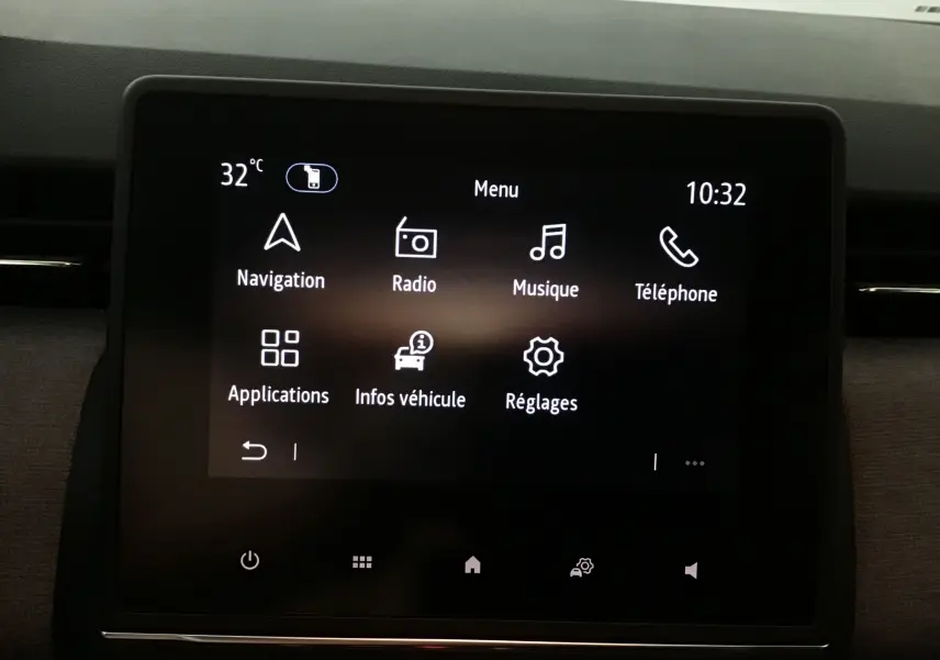 Écran tactile central de la Renault Clio V 2025 affichant le menu principal avec navigation, radio et téléphone.