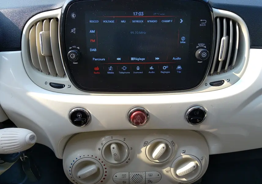 Tableau de bord blanc de la Fiat 500 1.0 Hybrid 2021 avec écran tactile et commandes de climatisation circulaires.