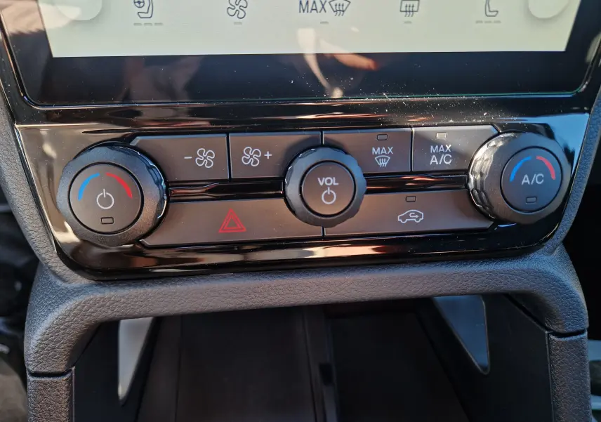 Gros plan sur les commandes de climatisation et volume du Ford Ranger Super Cabine gris Iconic, tableau de bord moderne.