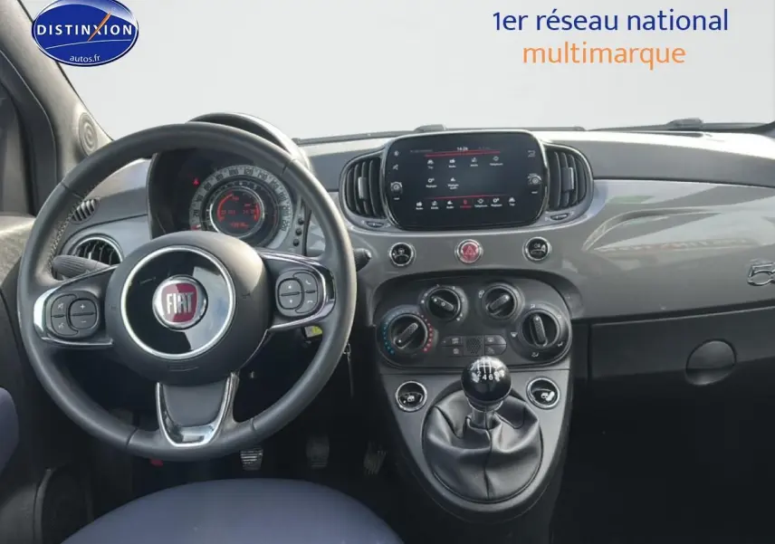 Vue intérieure du tableau de bord gris de la Fiat 500 1.0 70 bsg cult avec volant cuir et boîte manuelle.