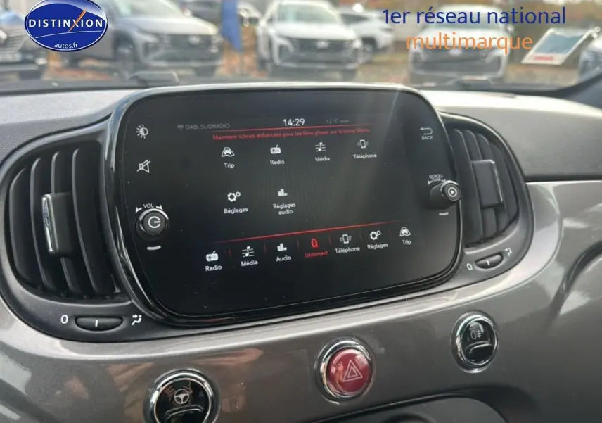 Écran tactile central et commandes de climatisation sur tableau de bord gris d'une Fiat 500 2022 vue de face.