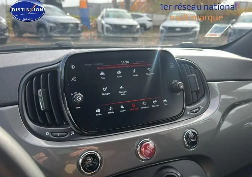 Vue intérieure centrée sur l'écran tactile et la console grise d'une Fiat 500 1.0 70 bsg cult de 2022.