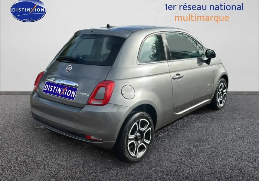 Vue 3/4 arrière droite d'une Fiat 500 gris métallisé avec jantes distinctives et vitres teintées.