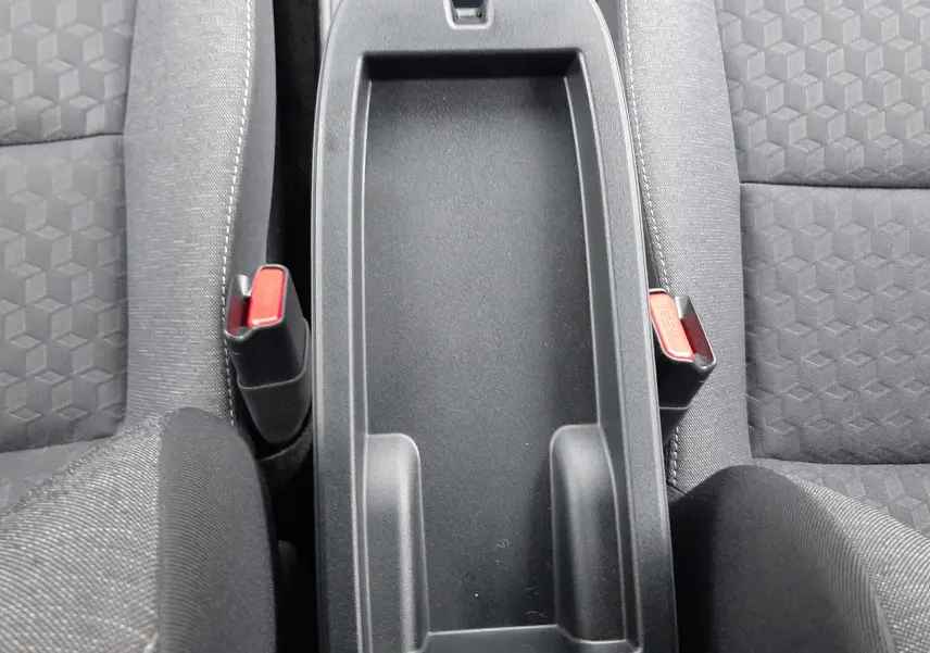 Vue plongeante sur la console centrale noire et les sièges tissu gris foncé de la Toyota Yaris 2023 hybride.