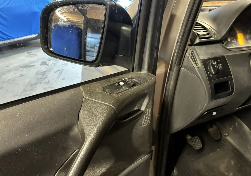 Vue intérieure côté gauche du Mercedes Vito gris 2012, montrant la portière avec commandes des vitres et rétroviseur.