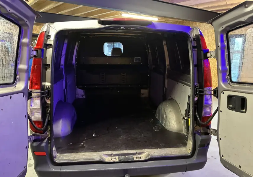 Vue arrière du fourgon long Mercedes Vito gris 2012 avec portes ouvertes dévoilant l’espace de chargement vide.