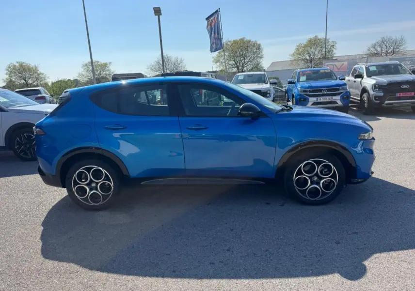 Vue de profil côté gauche d'un Alfa Romeo Tonale 2025 bleu foncé avec jantes distinctives à cinq cercles.
