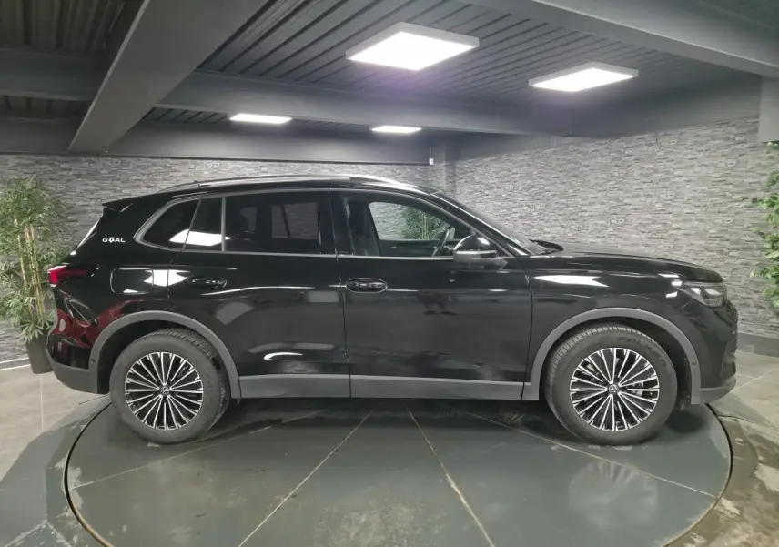 Vue de profil côté gauche d'un Volkswagen Tiguan noir 2025 avec jantes alliage et badge GOAL à l'arrière.