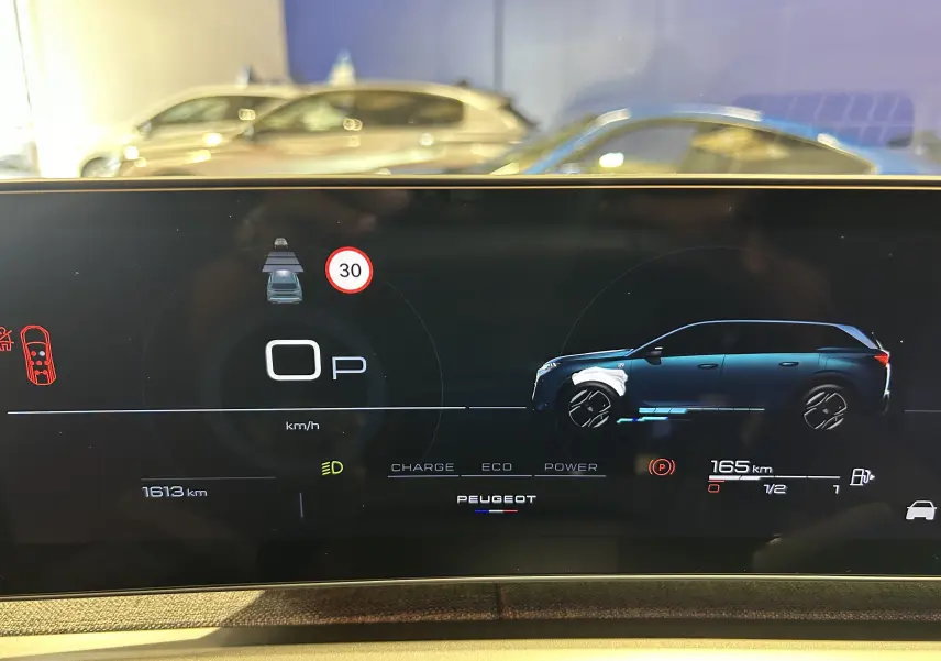 Affichage numérique du tableau de bord montrant la silhouette bleue du Peugeot 5008 Hybrid côté droit et les informations de conduite.